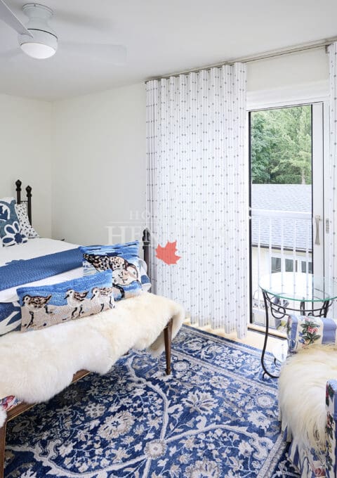 Interior view of a guest bedroom adorned with a variety of unique textiles, including patterned bedding, vibrant throw pillows, and eclectic decor, creating a warm and inviting space.