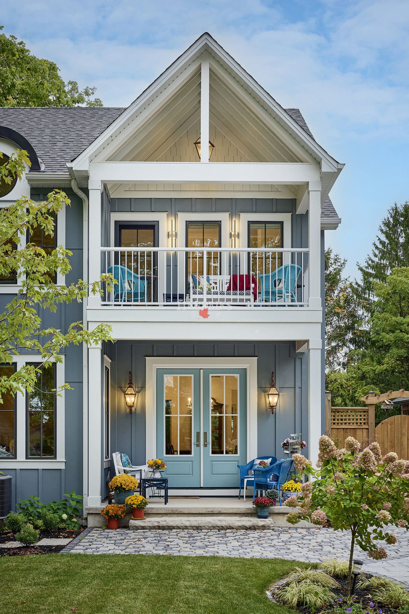 Exterior view of a coastal house in Niagara-on-the-Lake, featuring a charming balcony and boards and batten siding.