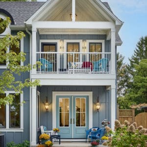 Exterior view of a coastal house in Niagara-on-the-Lake, featuring a charming balcony and boards and batten siding.