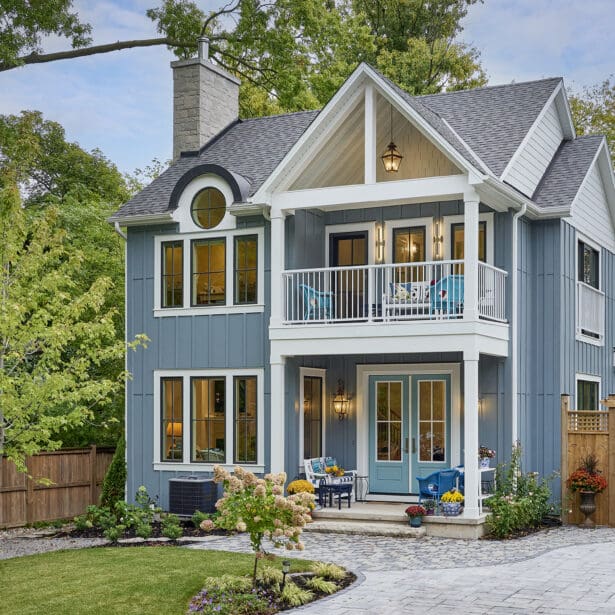 Exterior view of a coastal house in Niagara-on-the-Lake, showcasing a corner angle with a balcony and boards and batten siding.