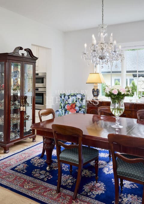 Interior view of a Victorian-inspired dining room featuring an elegant crystal chandelier, intricate moldings, and rich furnishings, creating a luxurious and timeless atmosphere.