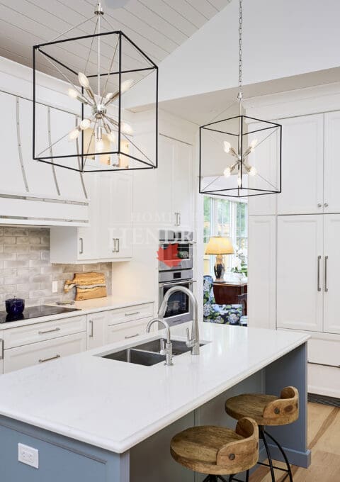 Interior view of a kitchen with white cabinetry, a vaulted ceiling, and hardwood flooring, creating a bright and open space.