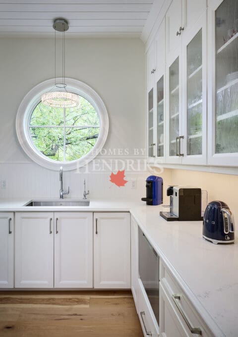 Interior view of a white butler's pantry, featuring ample storage, elegant cabinetry, and a clean, organized layout