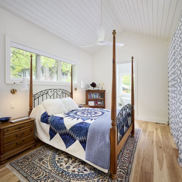 Interior view of a guest bedroom showcasing shiplap ceilings and hardwood flooring, creating a cozy and inviting atmosphere.